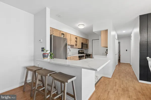 a kitchen with kitchen island a refrigerator stove and sink