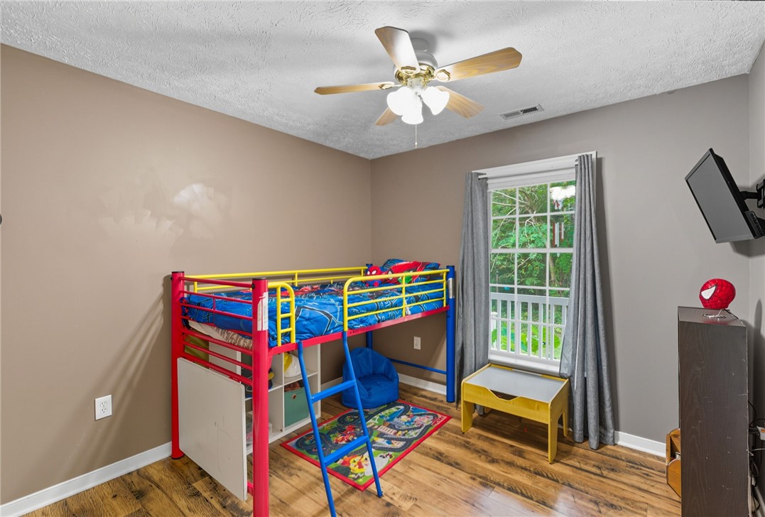 878 Salvia Road Newtown, VA 23126 - Photo 20 of 33 Bedroom featuring wood finished floors, ceiling fan, and a textured ceiling
