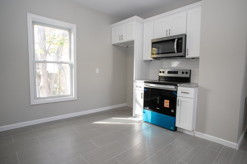 57-59 Cottage Street Athol, MA 01331 - Photo 17 of 42 a kitchen with granite countertop a stove top oven and sink