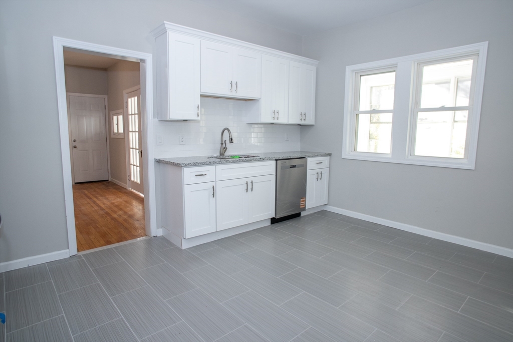57-59 Cottage Street Athol, MA 01331 - Photo 37 of 42 a kitchen with stainless steel appliances granite countertop a stove a sink and white cabinets