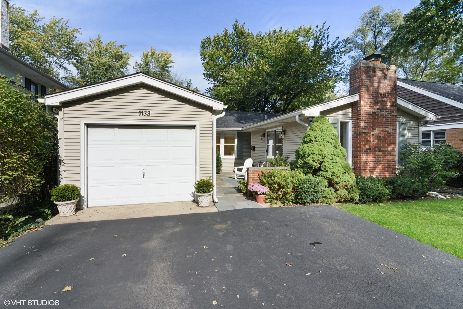 1133 Willow Road Winnetka, IL 60093 - Photo 1 of 26 a front view of a house with a yard and garage