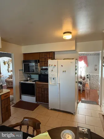 a kitchen with a refrigerator and a stove top oven