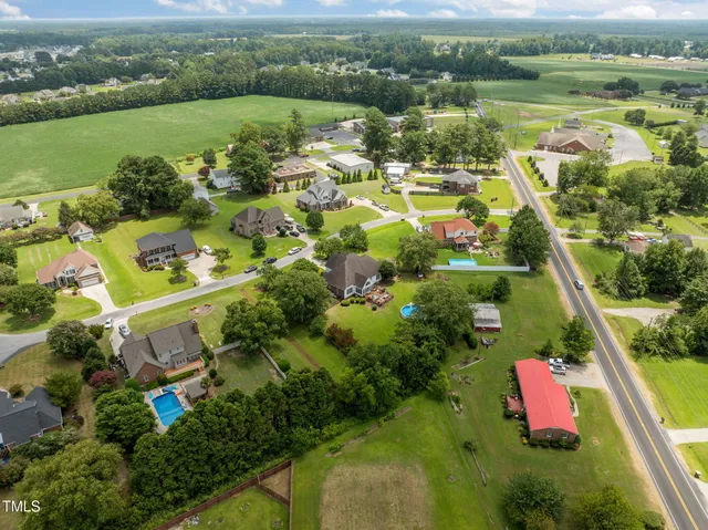 an aerial view of residential houses with outdoor space and lake view