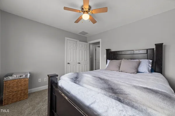 a bed sitting in a room next to a window and a chandelier