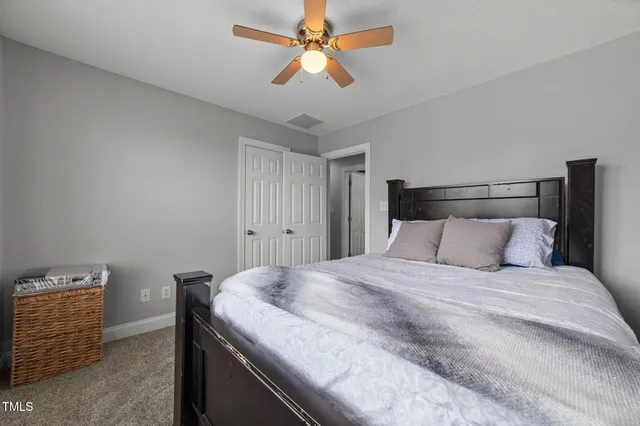 a bed sitting in a room next to a window and a chandelier