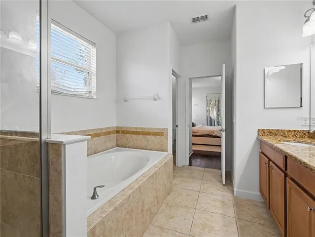 a bathroom with a tub sink and mirror