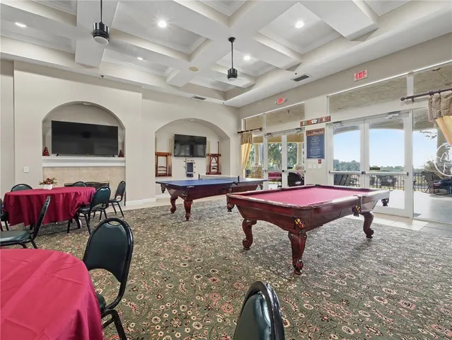 a living room with furniture a flat screen tv and kitchen view