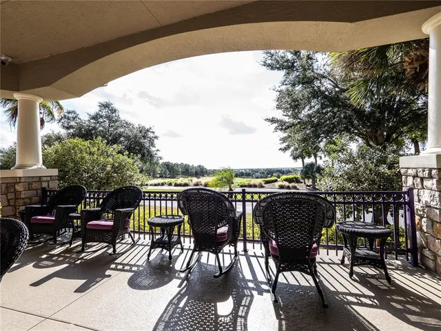 a view of a patio with table and chairs and floor to ceiling window