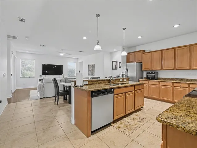 a kitchen with stainless steel appliances kitchen island granite countertop a sink and cabinets
