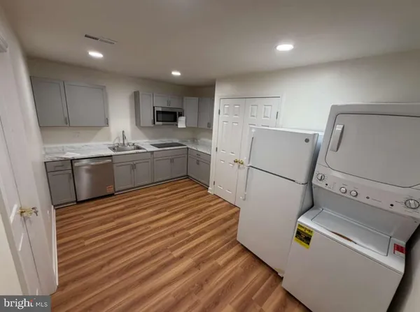 a kitchen with a sink a refrigerator and cabinets