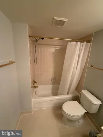 a white toilet sitting next to a bath tub