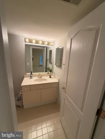 a bathroom with a sink and mirror with bathtub