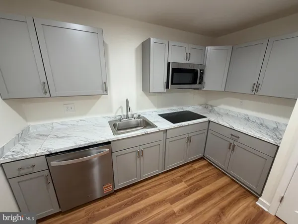 a kitchen with granite countertop white cabinets and white appliances