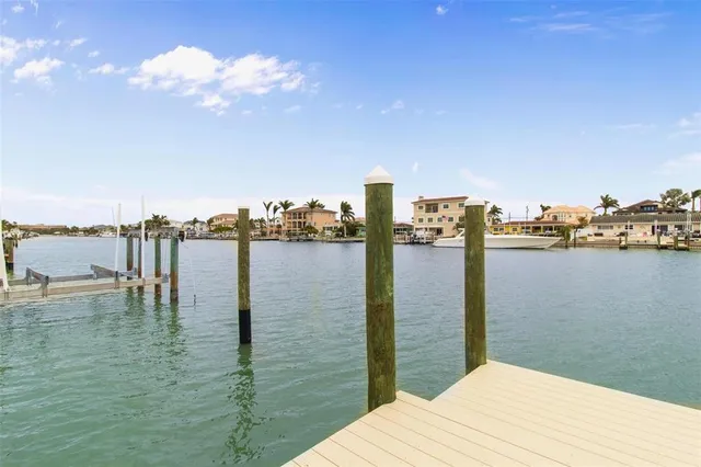 a front view of a house with a garden and lake view