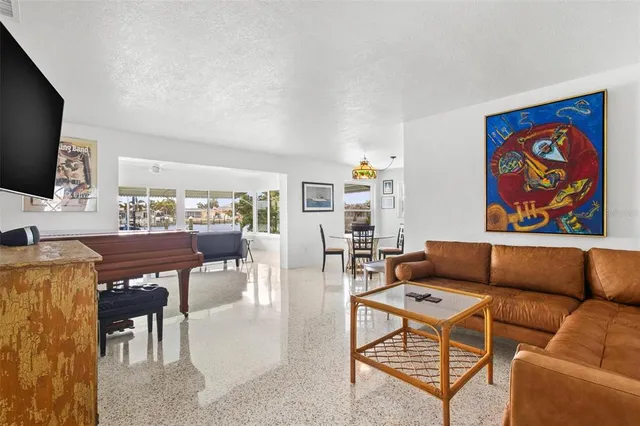 a living room with furniture a flat screen tv and kitchen view