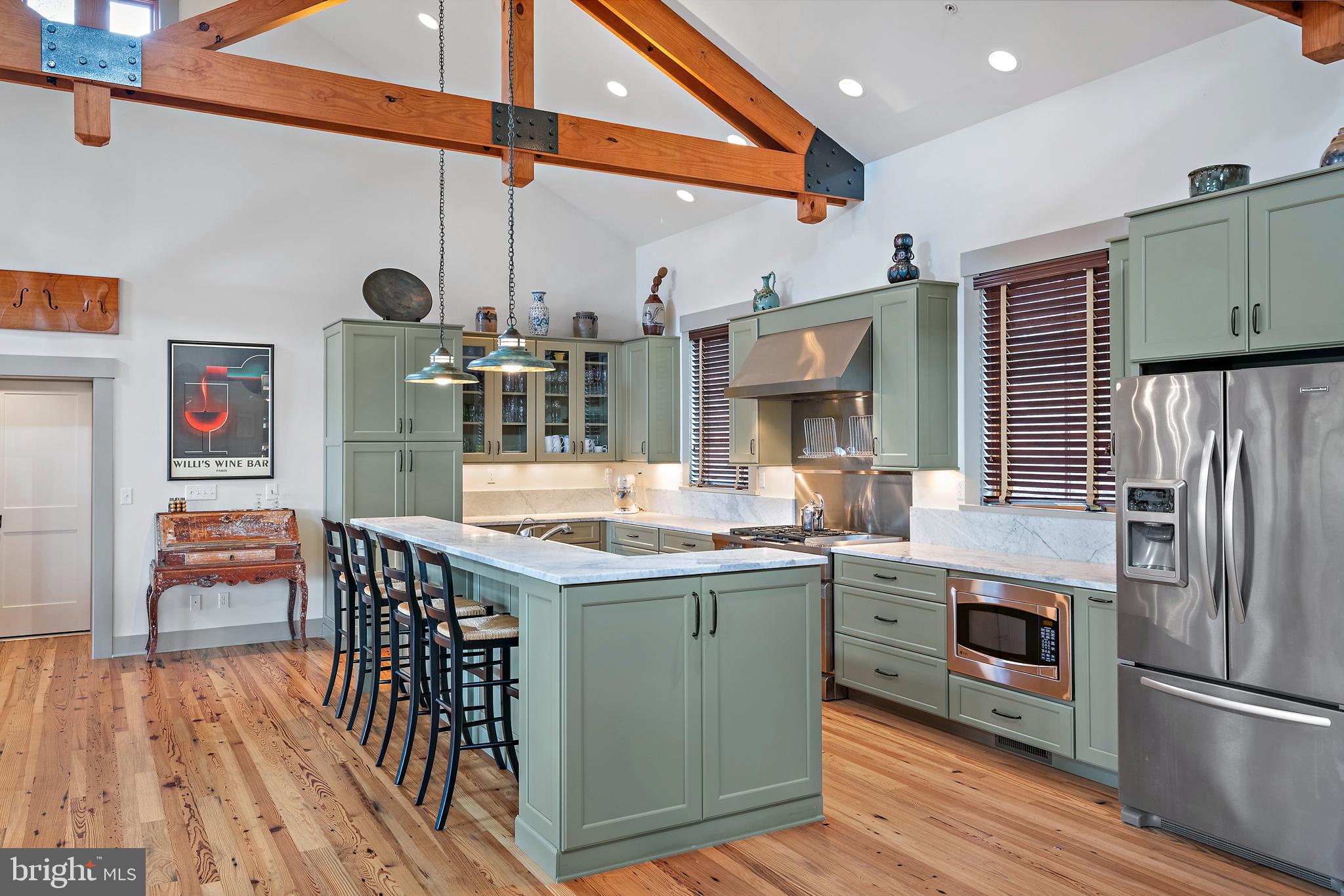 397 Forelands Road Annapolis, MD 21401 - Photo 30 of 83 a kitchen with stainless steel appliances kitchen island granite countertop a table chairs in it and wooden floors
