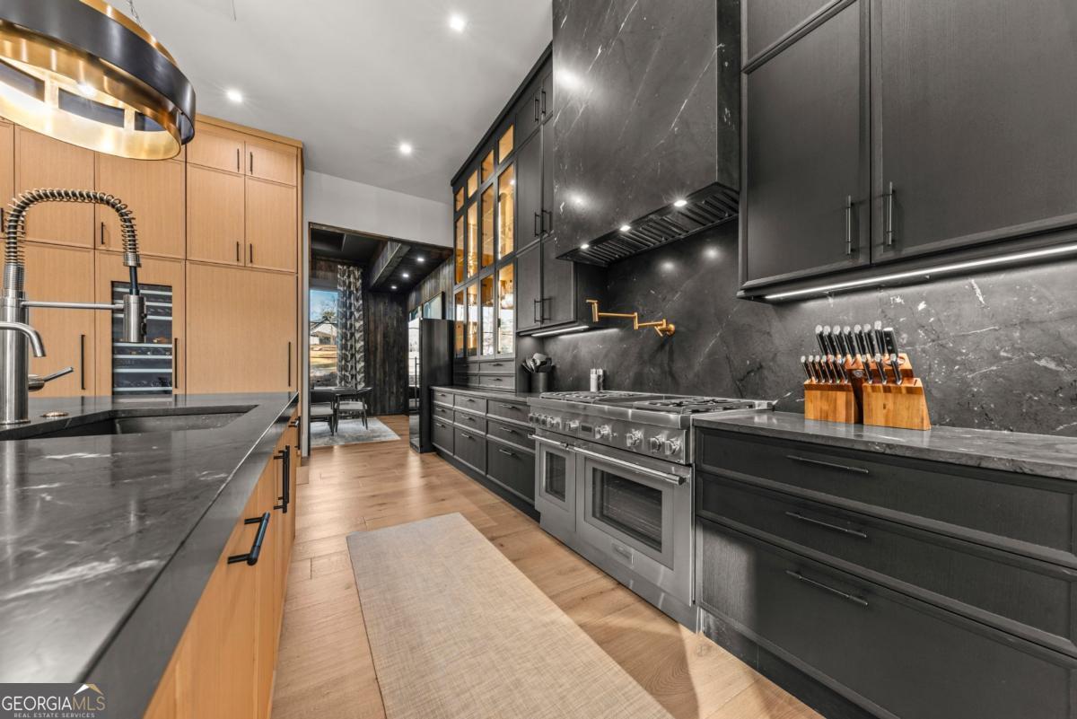 1131 Neary Ridge Greensboro, GA 30642 - Photo 16 of 72 a kitchen with stainless steel appliances granite countertop a sink counter space cabinets and living room view