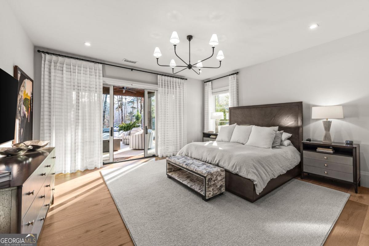1131 Neary Ridge Greensboro, GA 30642 - Photo 56 of 72 a spacious bedroom with a bed a chandelier and a large window