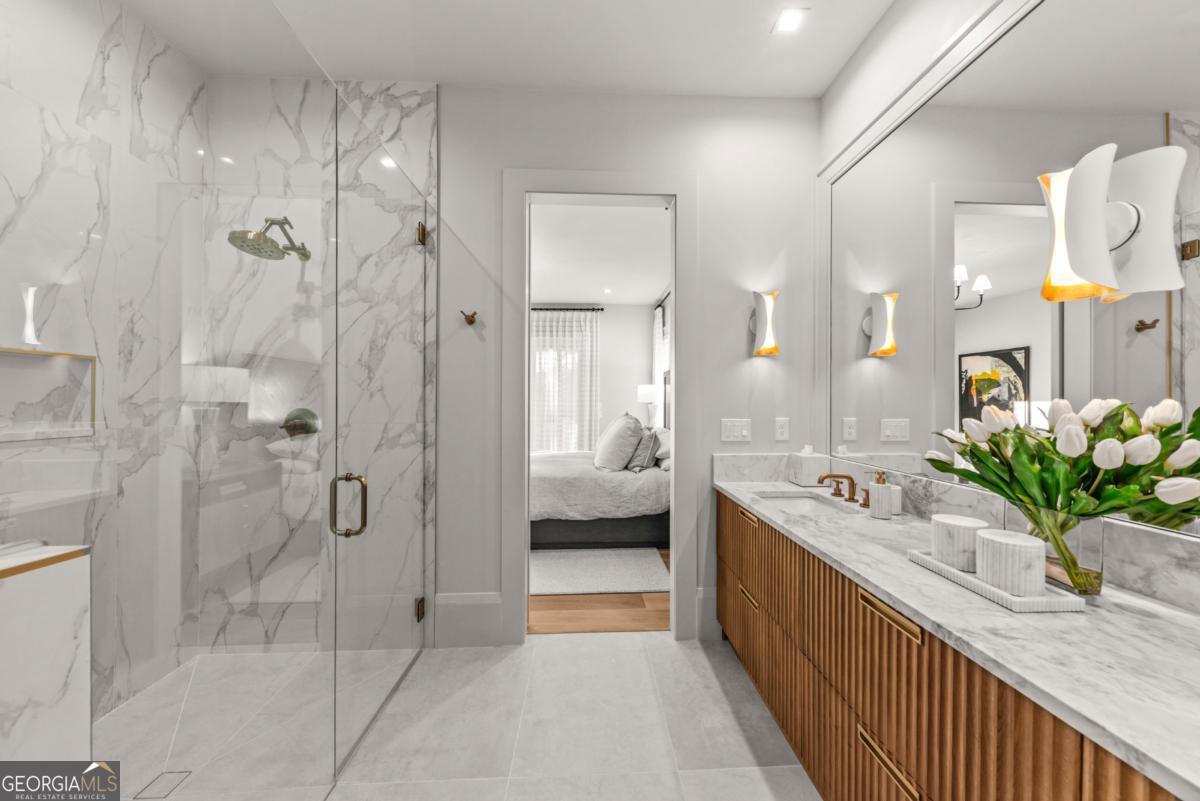 1131 Neary Ridge Greensboro, GA 30642 - Photo 57 of 72 a bathroom with a double vanity sink a large mirror a bathtub and shower