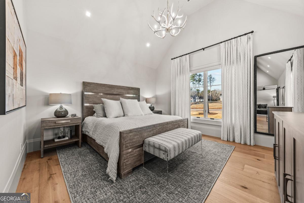 1131 Neary Ridge Greensboro, GA 30642 - Photo 63 of 72 a bedroom with a bed lamps and a large mirror on the dresser