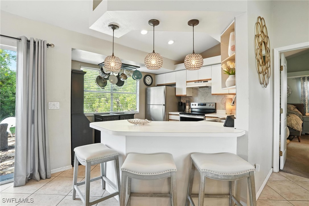 5242 17th Place Southwest Naples, FL 34116 - Photo 6 of 19 a kitchen with a dining table chairs stainless steel appliances and cabinets
