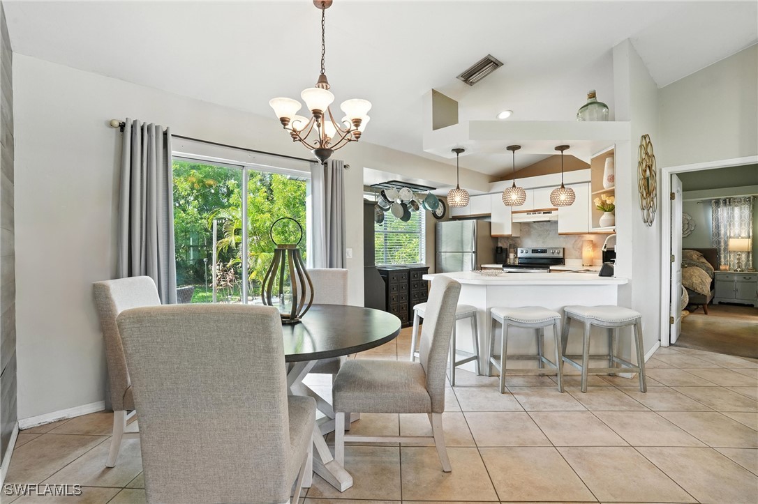 5242 17th Place Southwest Naples, FL 34116 - Photo 8 of 19 a view of a dining room with furniture a chandelier and large windows