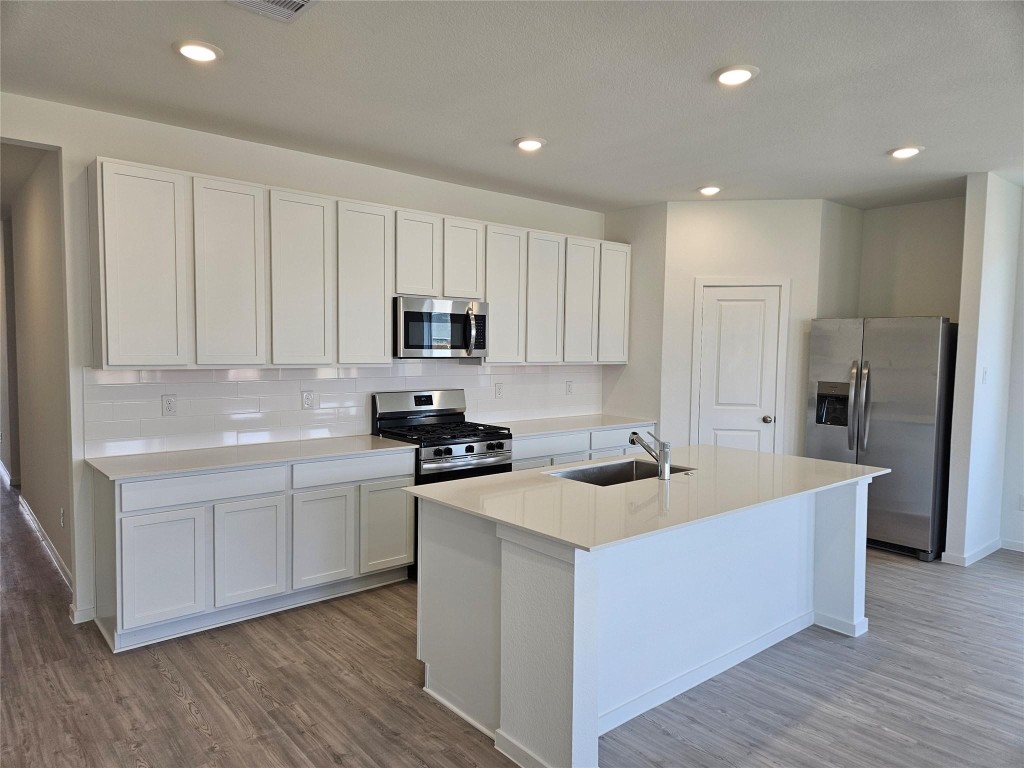 7915 Evening Emerald Drive Rosharon, TX 77583 - Photo 3 of 17 a kitchen with white cabinets and stainless steel appliances