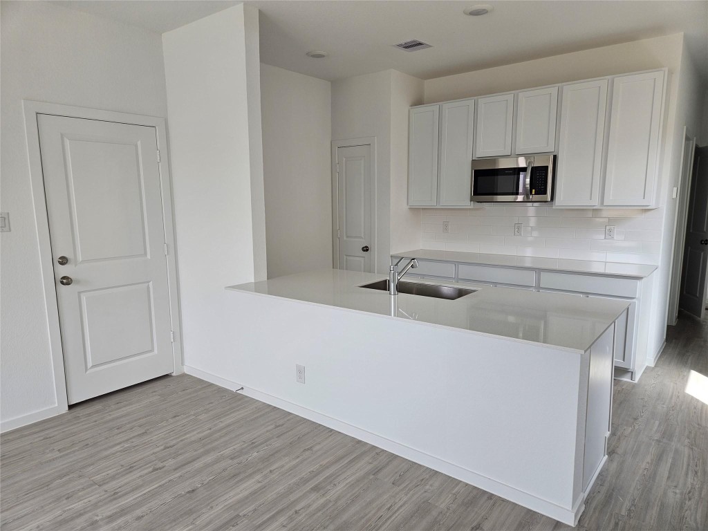 7915 Evening Emerald Drive Rosharon, TX 77583 - Photo 4 of 17 a kitchen with stainless steel appliances granite countertop a sink a microwave counter space and cabinets