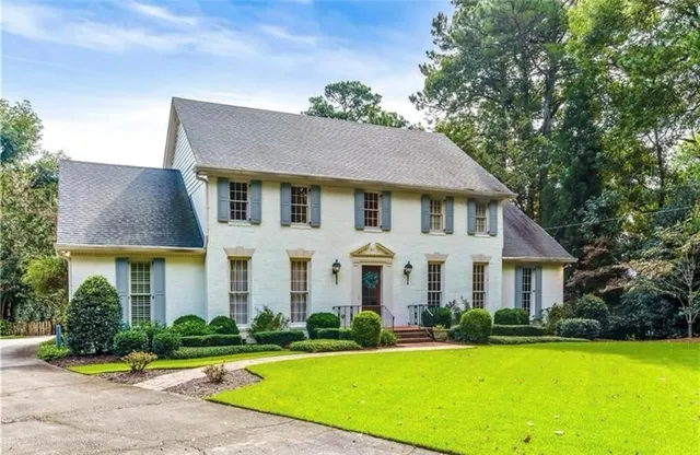 a front view of a house with yard and green space