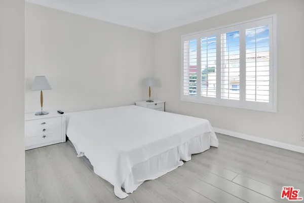 a spacious bedroom with a bed and a window