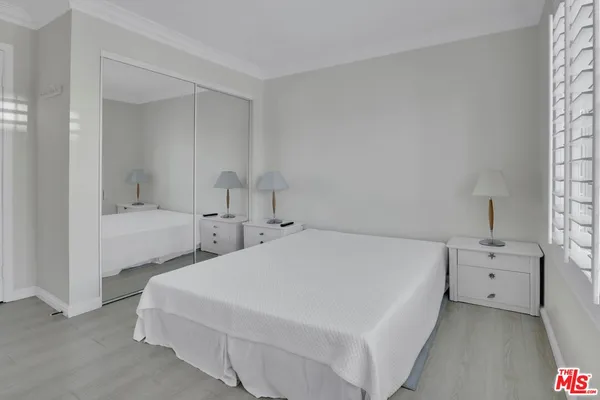 a bedroom with a bed and a lamp on desk