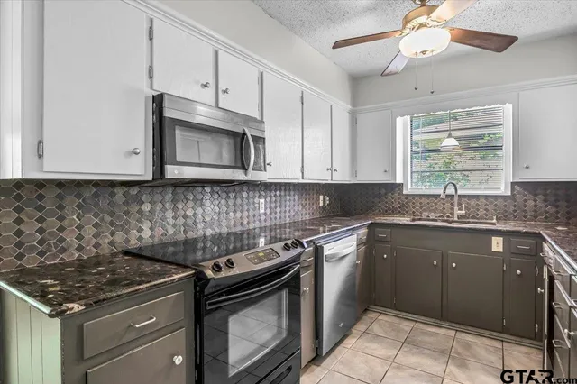 a kitchen with stainless steel appliances granite countertop a stove a sink and a microwave