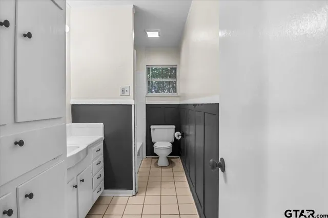 a bathroom with a toilet sink and mirror