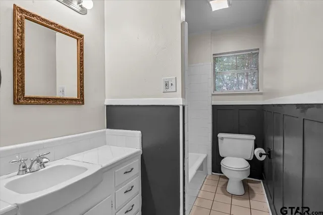 a bathroom with a toilet a sink and mirror