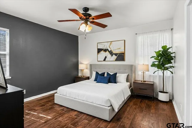 a bedroom with a large bed and a potted plant