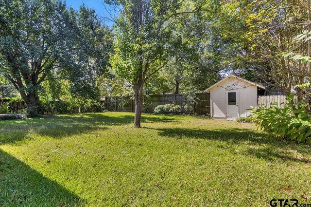 a front view of a house with garden and trees