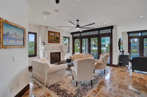 a living room with furniture ceiling fan and a large window