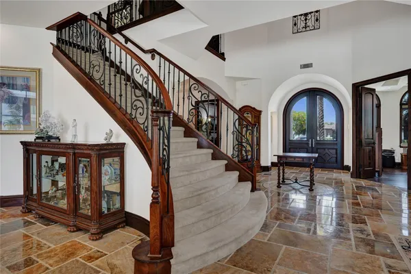 a hallway with wooden floor fireplace and windows