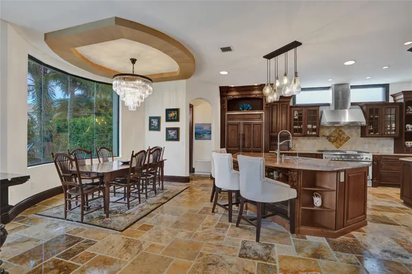 a kitchen with stainless steel appliances granite countertop a sink a stove and a refrigerator