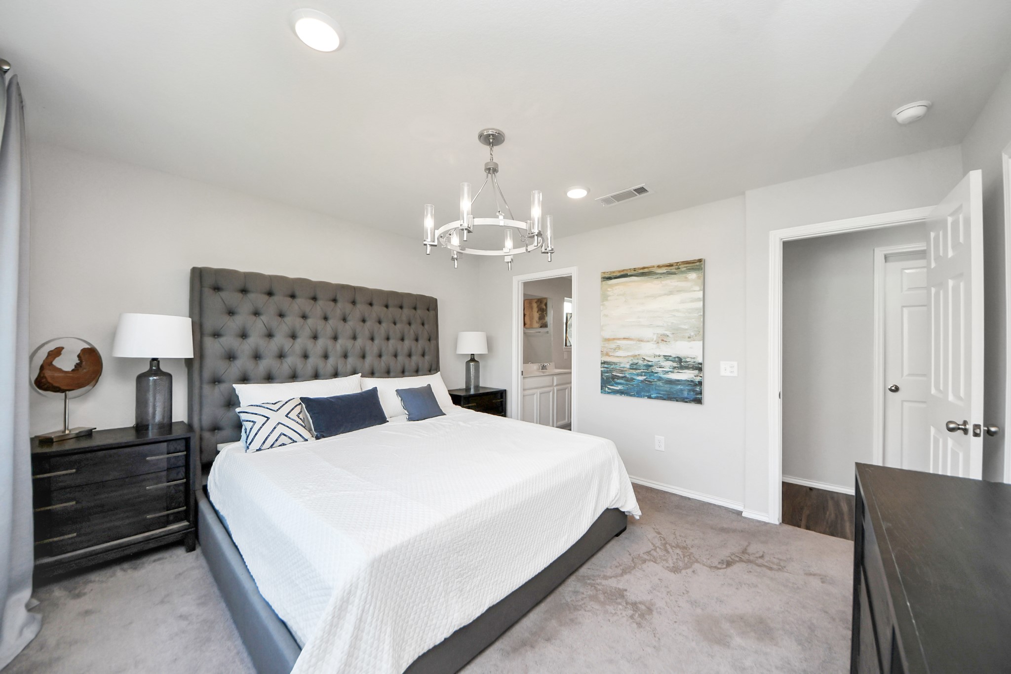 5735 Prairie Chapel Road Katy, TX 77493 - Photo 15 of 19 a bedroom with a large bed and a chandelier