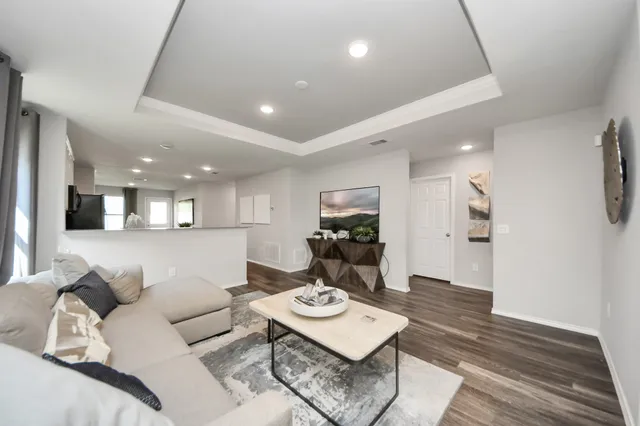 a living room with furniture and a wooden floor