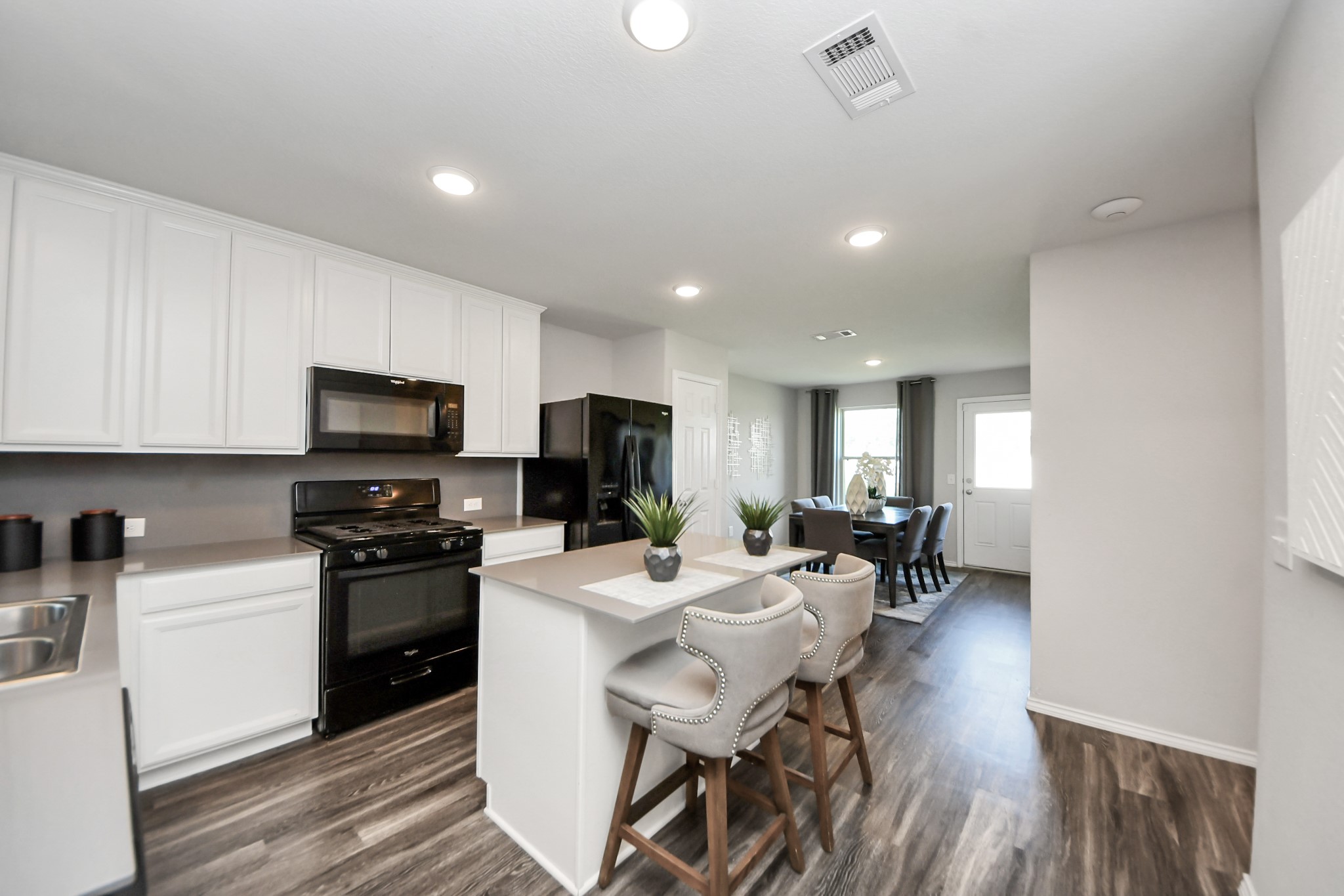 5735 Prairie Chapel Road Katy, TX 77493 - Photo 9 of 19 a kitchen with stainless steel appliances kitchen island granite countertop a sink a stove a dining table and chairs