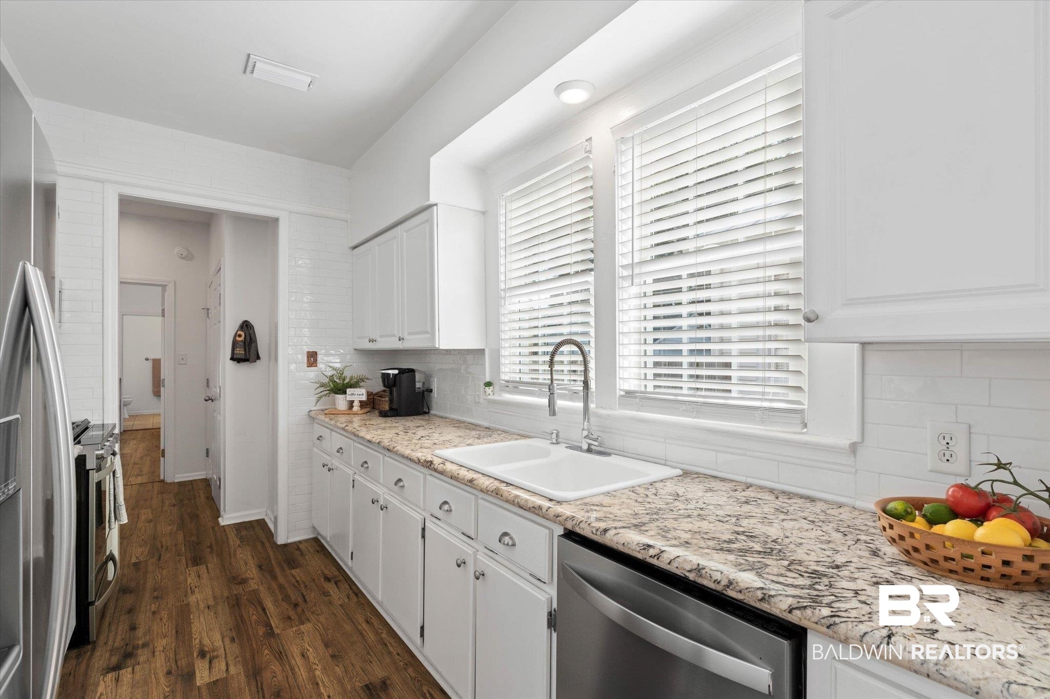 1910 Hunter Avenue Mobile, AL 36606 - Photo 7 of 21 Kitchen with stainless steel appliances, a sink, decorative backsplash, and white cabinets