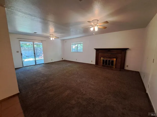 an empty room with windows and fireplace