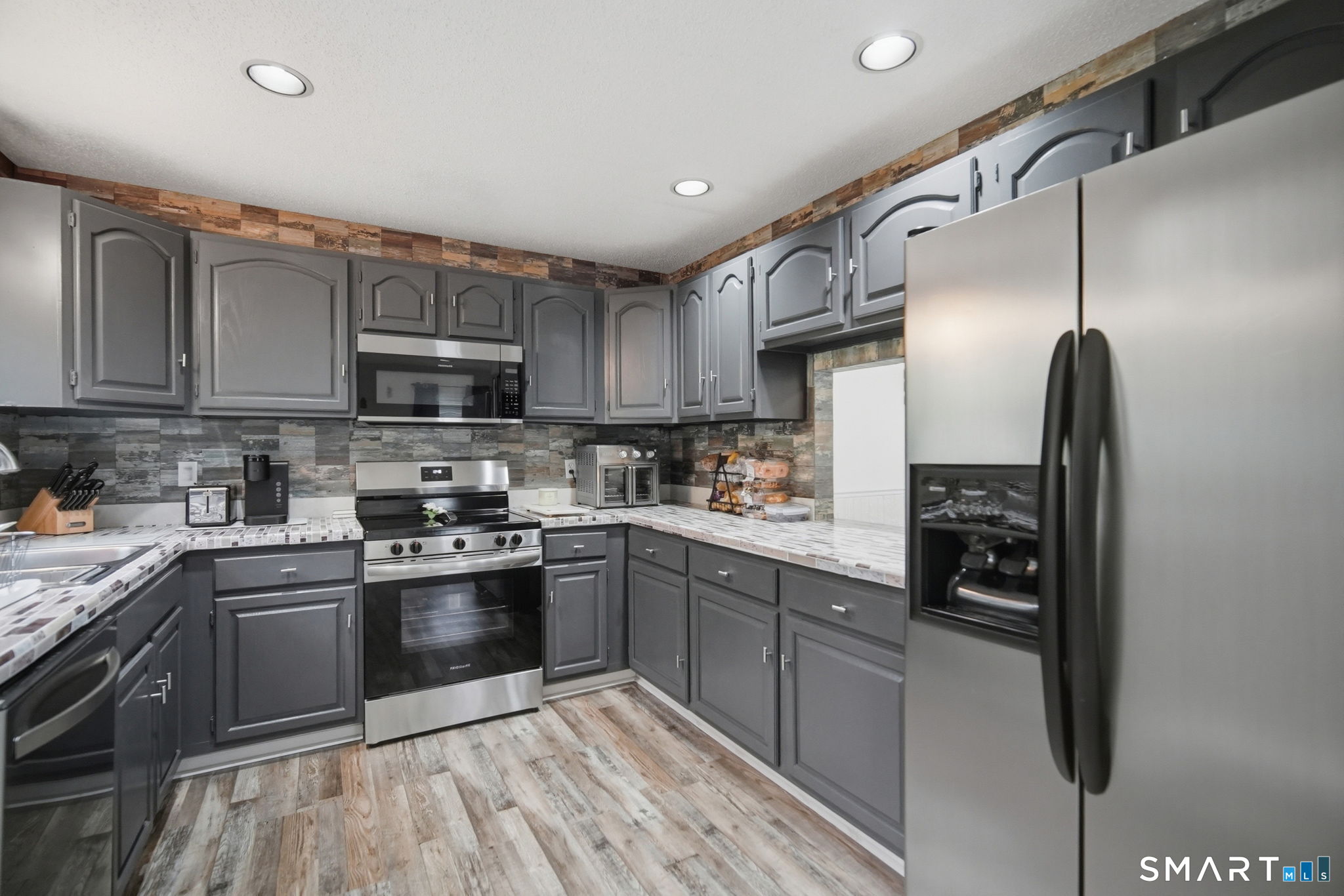 350 Bristol Street, Unit C12 Waterbury, CT 06708 - Photo 11 of 40 a kitchen with stainless steel appliances granite countertop a refrigerator a stove top oven a sink and dishwasher