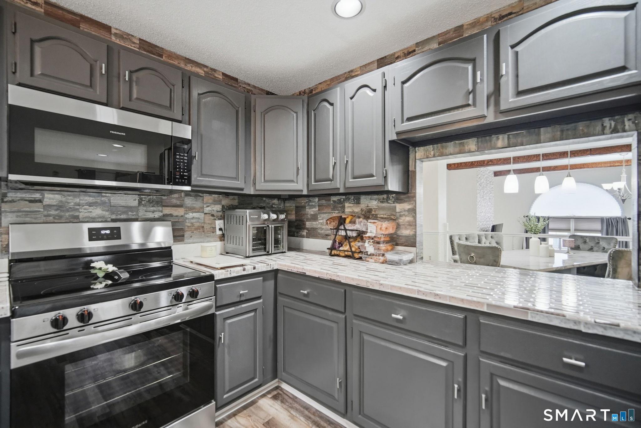 350 Bristol Street, Unit C12 Waterbury, CT 06708 - Photo 8 of 40 a kitchen with stainless steel appliances granite countertop a stove microwave and cabinets
