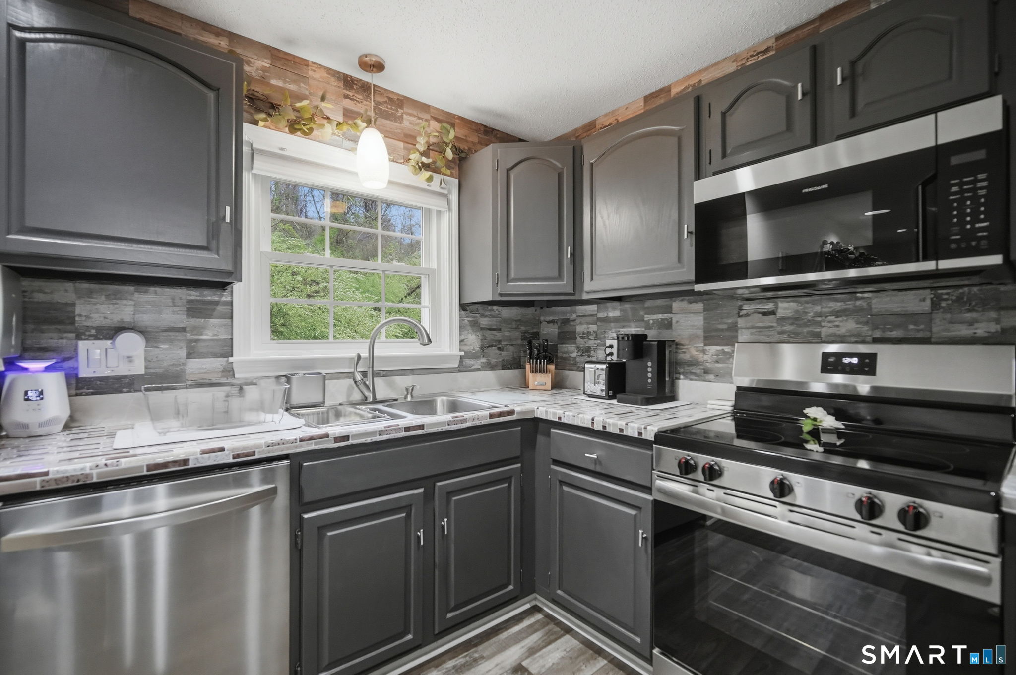 350 Bristol Street, Unit C12 Waterbury, CT 06708 - Photo 9 of 40 a kitchen with stainless steel appliances granite countertop a sink stove microwave and cabinets