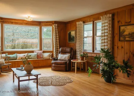 a living room with furniture and a floor to ceiling window