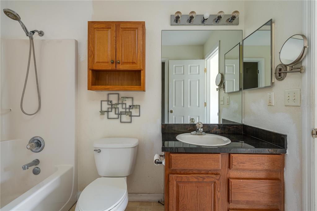403 Southeast 3rd Street Fort Meade, FL 33841 - Photo 13 of 30 a bathroom with a granite countertop sink and a mirror