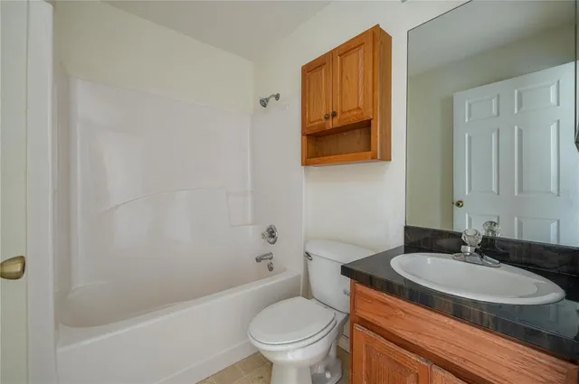 a bathroom with a granite countertop sink toilet and a bathtub